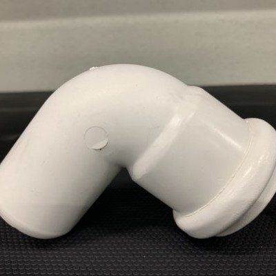 Tubo curvo branco de PVC sobre superfície preta