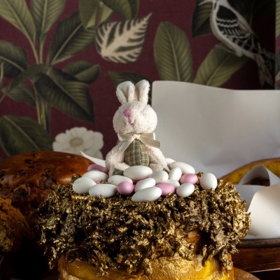 Bolo decorado com coelho de peluche e amêndoas de açúcar em base com ilustrações de coelhos