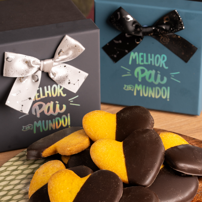 Caixas de presente com biscoitos em forma de coração cobertos parcialmente com chocolate.