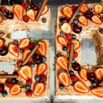 Bolo em forma dos números 5 e 0 com frutas frescas e chocolate por cima