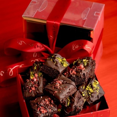 Caixa vermelha com pedaços de bolo de chocolate decorados