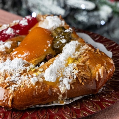 Fatia de bolo rei decorado com frutas cristalizadas e açúcar em pó