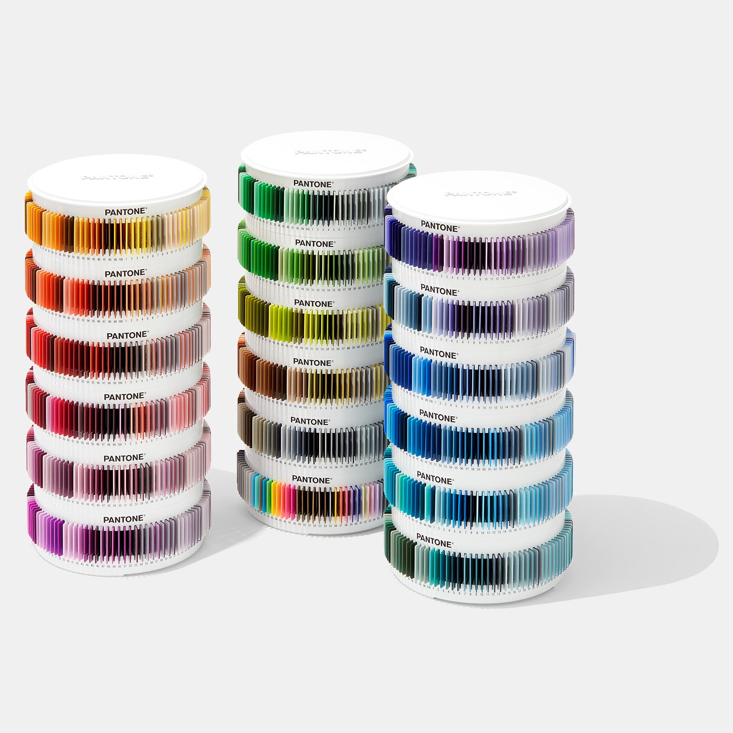 Pantone Plus Plastic Standard Chips Collection Rolos de fitas coloridas Pantone empilhados por cores em fundo branco.