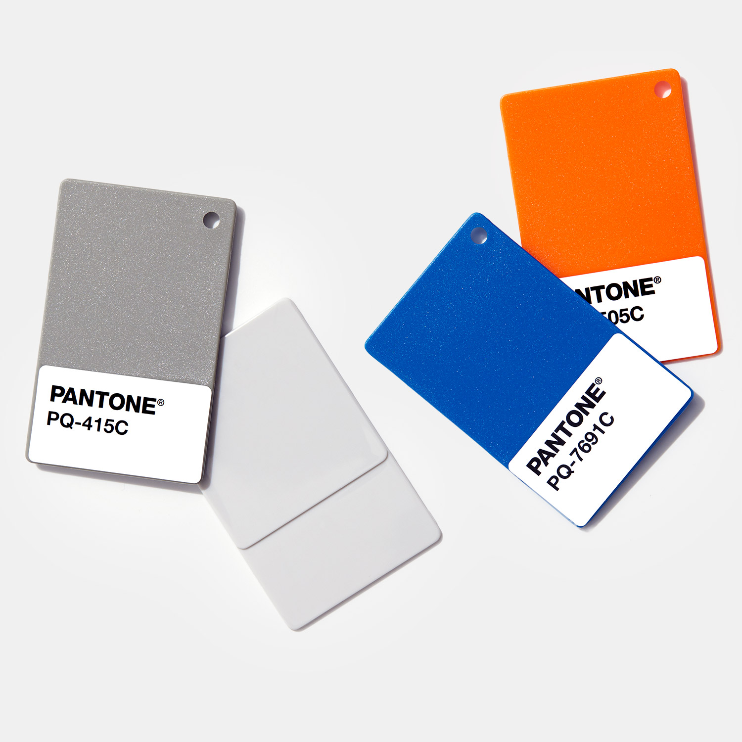Amostras coloridas de plástico Pantone cinzento, branco, azul e laranja com etiquetas e perfuração