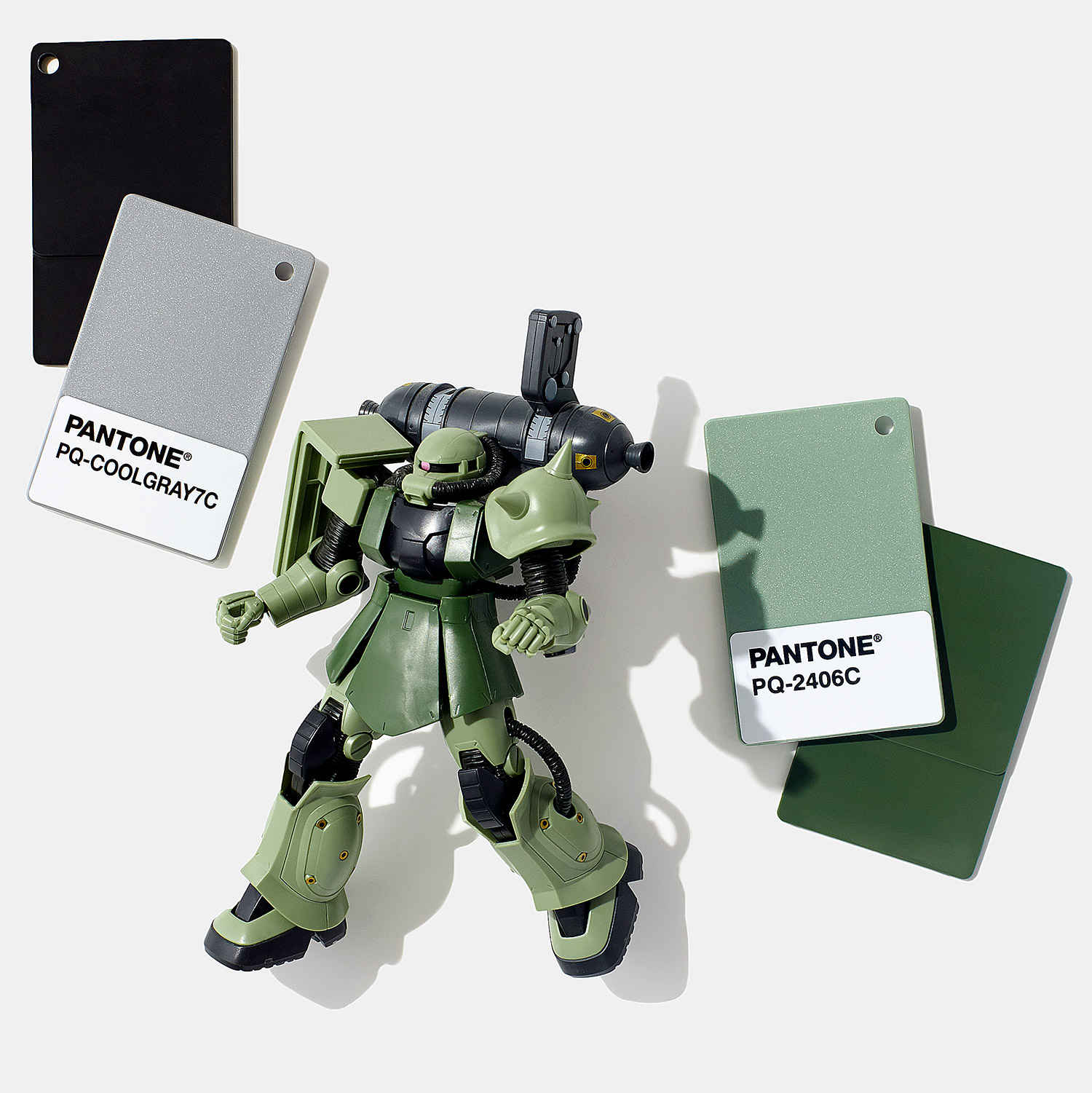 Figura robô verde com amostras de cor Pantone preta, cinza e verde