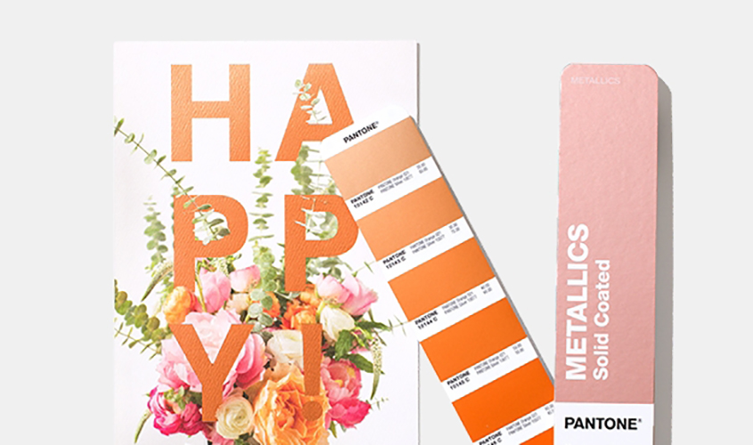 Cartão com a palavra HAPPY, flores coloridas, paleta Pantone laranja e amostra METALLICS Solid Coated.