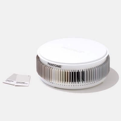 Mostrador circular Pantone branco e cinzento com amostras de cores e dois cartões Pantone ao lado