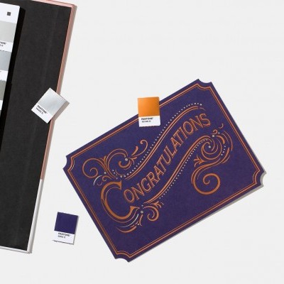 Cartão azul com texto dourado CONGRATULATIONS, amostras de cores e catálogo Pantone