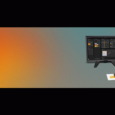 Equipamento de leitura digital com ecrã e base com etiquetas coloridas numa mesa com fundo gradiente laranja e cinzento