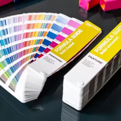 Catálogos de amostras de cores Pantone com capas amarelas sobre mesa escura