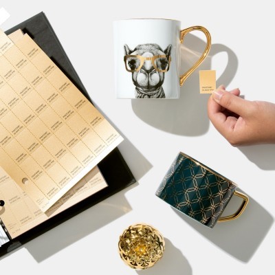 Duas canecas decorativas com caixas e folhetos em fundo branco