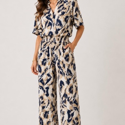 Mulher com macacão estampado azul, bege e branco com calças largas