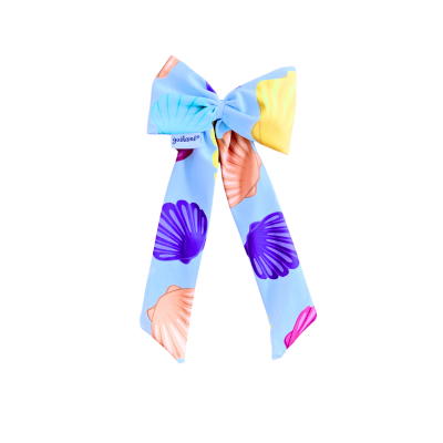 Laço azul claro com padrão de conchas coloridas e etiqueta jacaran