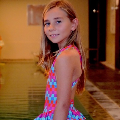 Rapaz com fato de banho colorido junto a piscina interior