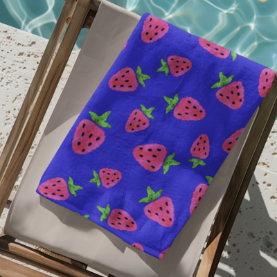 Toalha azul com morangos sobre cadeira de madeira ao lado da piscina