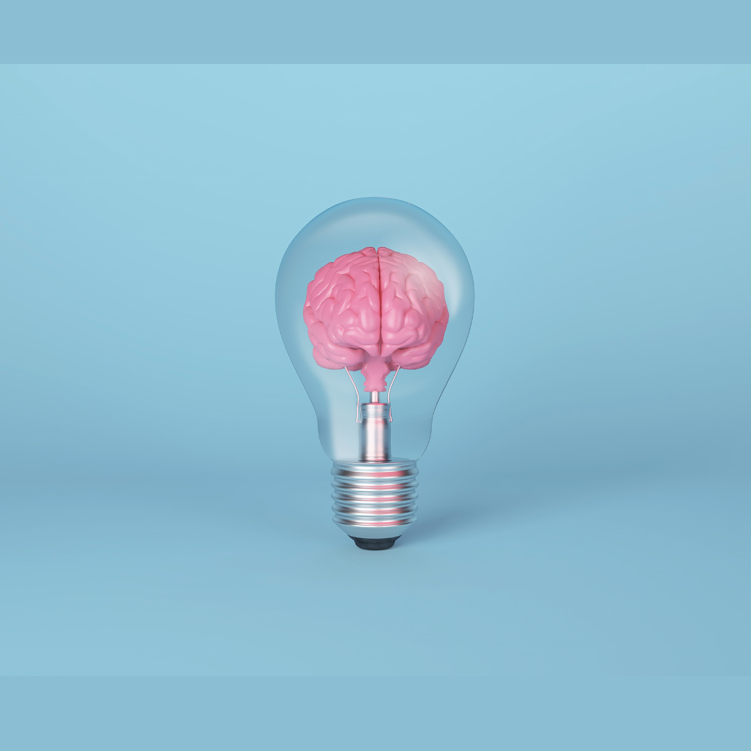 Lâmpada transparente com cérebro cor de rosa dentro em fundo azul claro