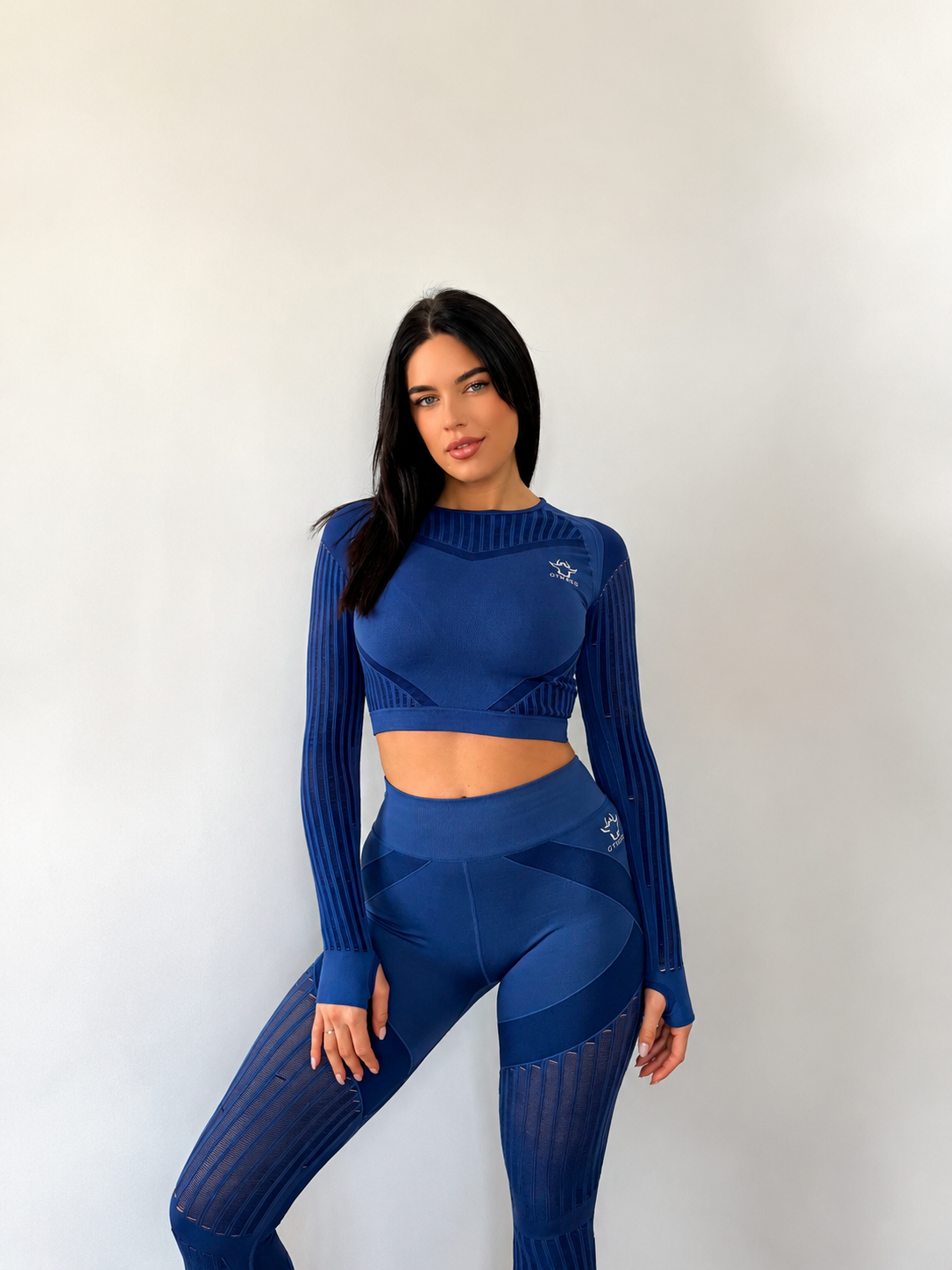 Conjunto desportivo azul escuro com leggings e top de manga comprida com detalhes em malha