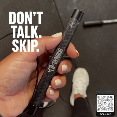 Mala preta antiderrapante Gymbug segurada à mão em ginásio com sapatilhas brancas