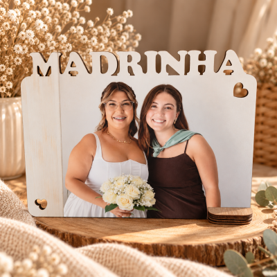 Moldura em madeira clara com a palavra MADRINHA e corações decorativos, com foto de duas mulheres sorrindo.