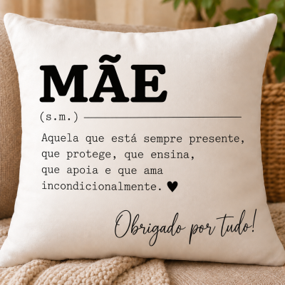 Almofada branca com texto preto dedicado à mãe colocada em sofá com manta bege.