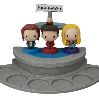 Figuras Funko Pop três personagens com base cinza e azul e letreiro FRIENDS