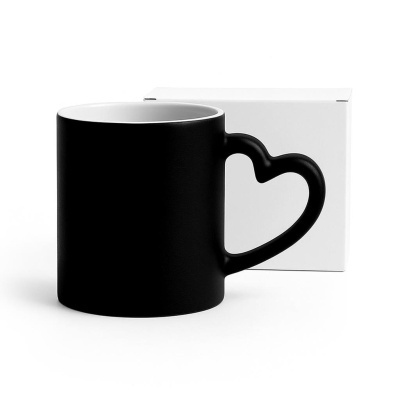 Caneca preta com pega em forma de coração à frente de caixa branca