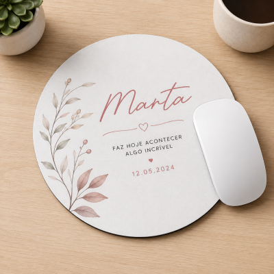 Tapete de rato redondo branco personalizado com nome Marta e texto motivacional, decorado com ilustração de folhas em tons naturais, sobre mesa de madeira clara com rato branco, chávena e planta.