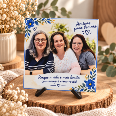 Placa decorativa com foto de três mulheres, texto em português e flores azuis sobre suporte