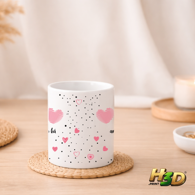 Caneca branca com corações rosa e manchas pretas numa mesa clara