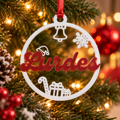 Enfeite de Natal circular branco com palavra Lurdes em vermelho pendurado em árvore com luzes.