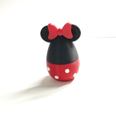 Figura decorativa com forma de cabeça de rato preta com laço vermelho e saia vermelha com bolinhas brancas