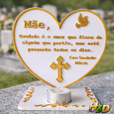 Lembrança em forma de coração com mensagem para mãe, decorada em dourado e com vela, colocada sobre mesa de pedra num cemitério