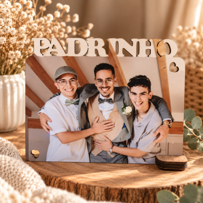 Porta-retratos de madeira com a palavra PADRINHO e foto de três homens sorridentes em ambiente interno