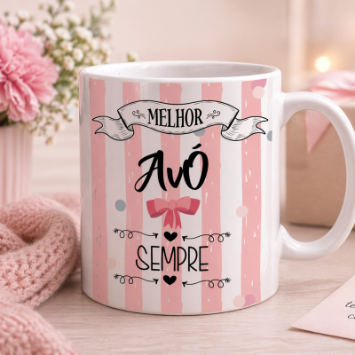 Caneca com texto Melhor Avó Sempre, laço rosa, flores cor de rosa e nota carinhosa em mesa de madeira clara