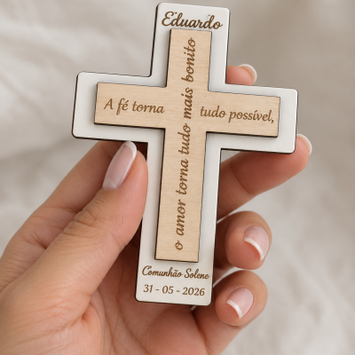 Cruz de madeira clara com gravação e base branca segurada em mão