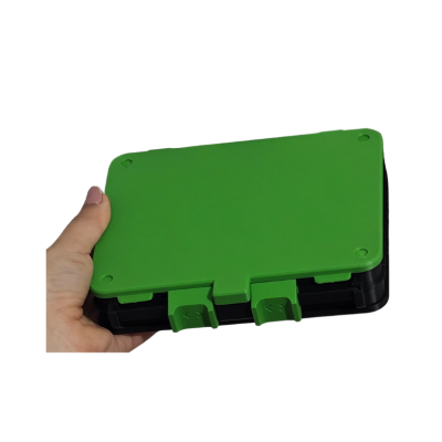 Caixa plástica verde e preta com fechos segurada por uma mão