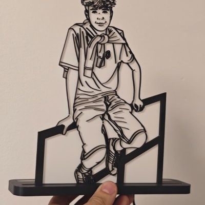 Luminária decorativa em acrílico com desenho de jovem sentado.