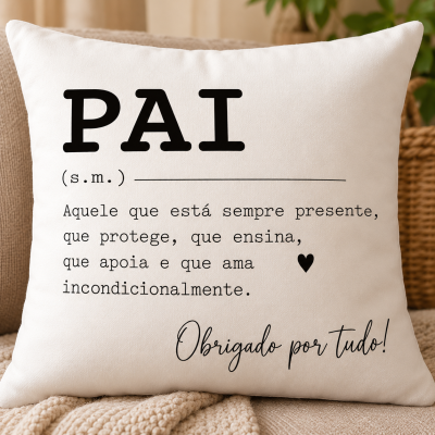 Travesseiro branco com texto em português sobre pai, sobre sofá bege e manta de tricô.