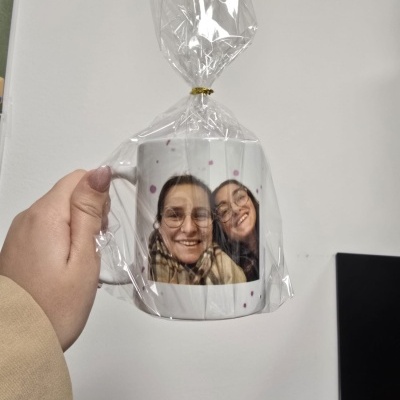 Caneca branca com fotografia de duas mulheres embrulhada em película plástica
