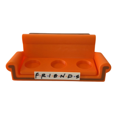 Suporte de plástico laranja em forma de sofá com texto FRIENDS