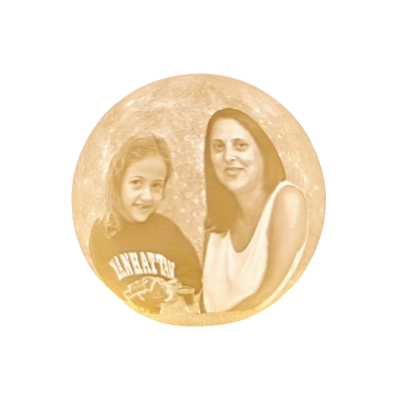 Imagem gravada em objeto redondo com menina e mulher em fundo de lua