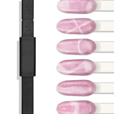 Dispositivo preto com botões e cinco unhas postizas rosadas com padrões brancos.