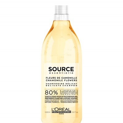Garrafa transparente de shampoo amarelo claro da L'Oréal com texto informativo em francês e inglês.