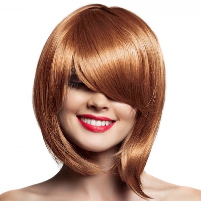 Mulher com peruca castanha curta e sorriso, fundo branco.