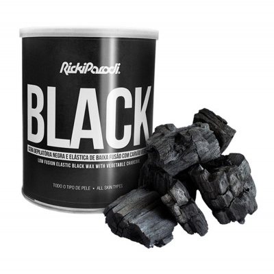 Lata de cera depilatória preta com carvão ao lado