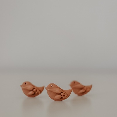 Três pássaros decorativos de cerâmica castanha