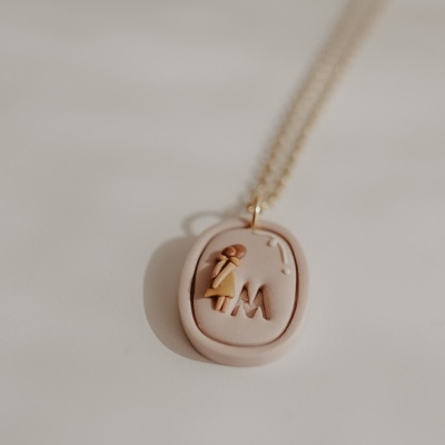 Colar com pendente oval rosa claro com relevo e corrente dourada