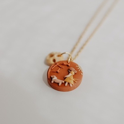 Colar com pendente redondo terracota com menina e cão em relevo