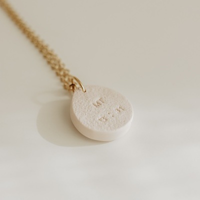 Colar com pendente redondo branco texturizado com texto gravado