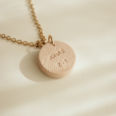 Colar com pendente redondo bege de textura irregular e corrente dourada